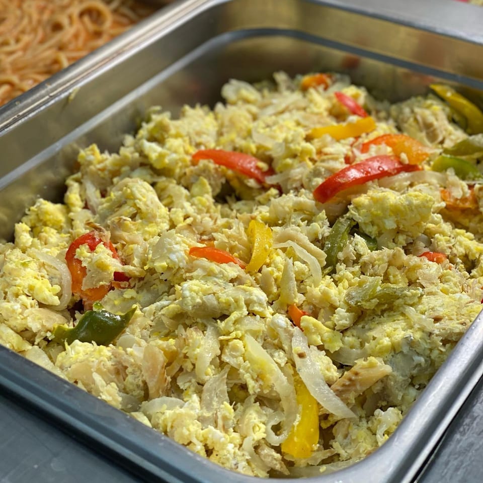 Scrambled eggs with colorful bell peppers and onions in a metal serving tray at Ana Restaurant.